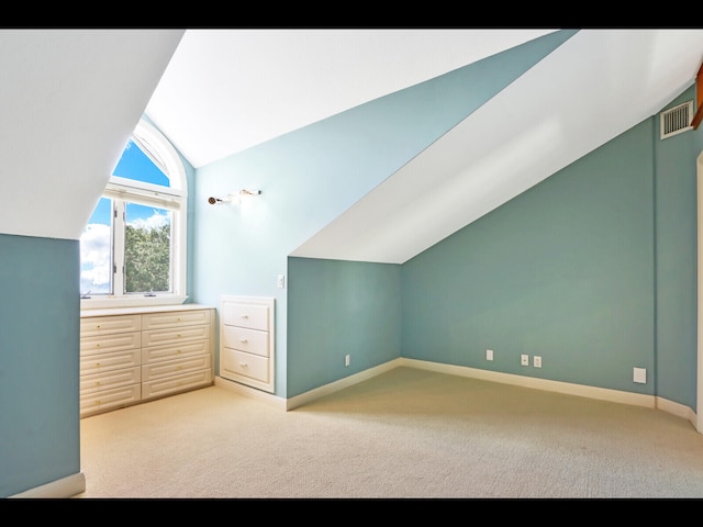 bonus room featuring lofted ceiling and light colored carpet