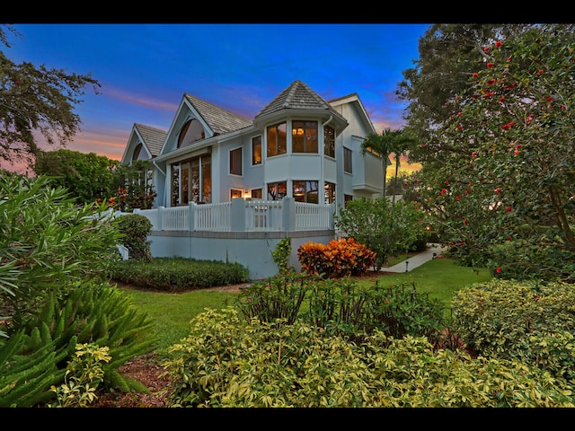 property exterior at dusk with a lawn