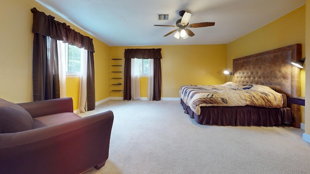 carpeted bedroom with multiple windows and ceiling fan