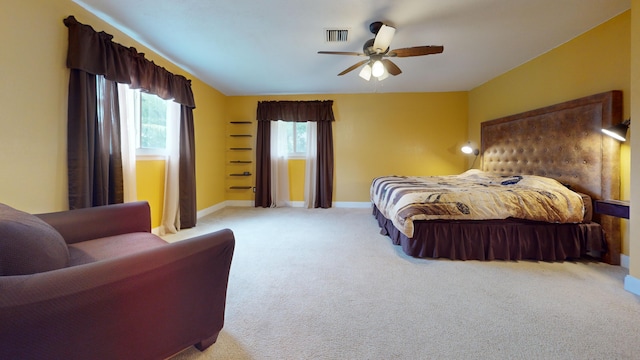 bedroom featuring baseboards, ceiling fan, visible vents, and light carpet