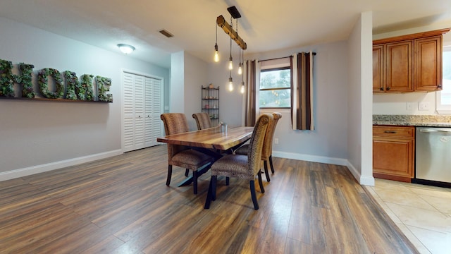 dining room featuring baseboards, plenty of natural light, and wood finished floors