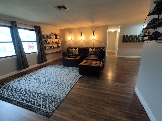 living room featuring baseboards, visible vents, and wood finished floors
