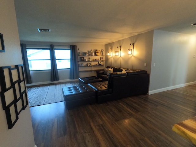 living area featuring visible vents, baseboards, and wood finished floors