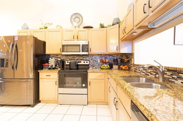 kitchen with appliances with stainless steel finishes, sink, light tile patterned floors, and light brown cabinets