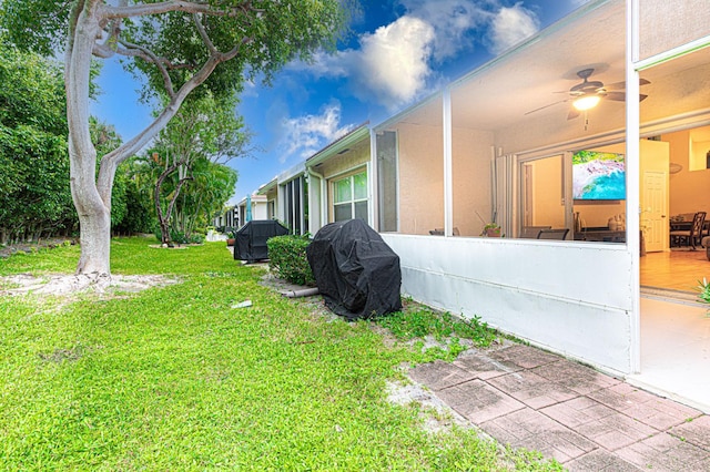 view of home's exterior featuring ceiling fan, a lawn, and a patio area