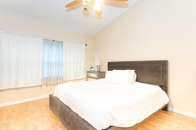 bedroom featuring ceiling fan, light wood-type flooring, and lofted ceiling