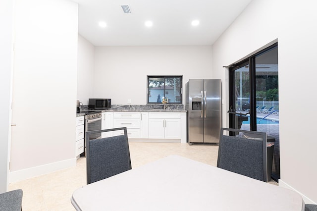 kitchen featuring stainless steel appliances, white cabinetry, and sink