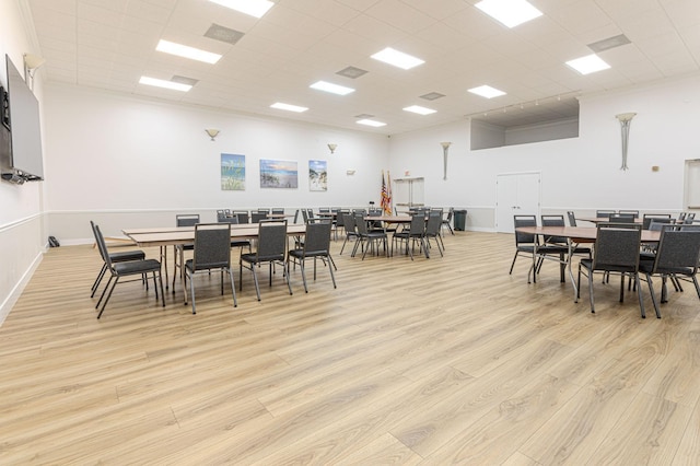 dining room with a drop ceiling and light hardwood / wood-style flooring