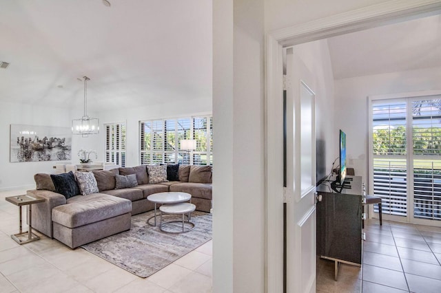 tiled living room with a healthy amount of sunlight and an inviting chandelier