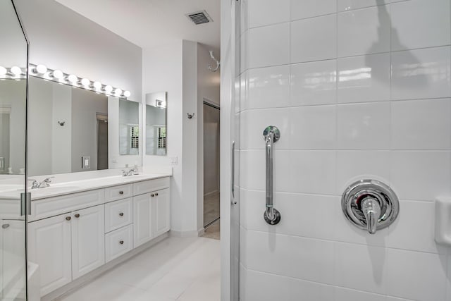 bathroom featuring vanity, tile patterned floors, and walk in shower