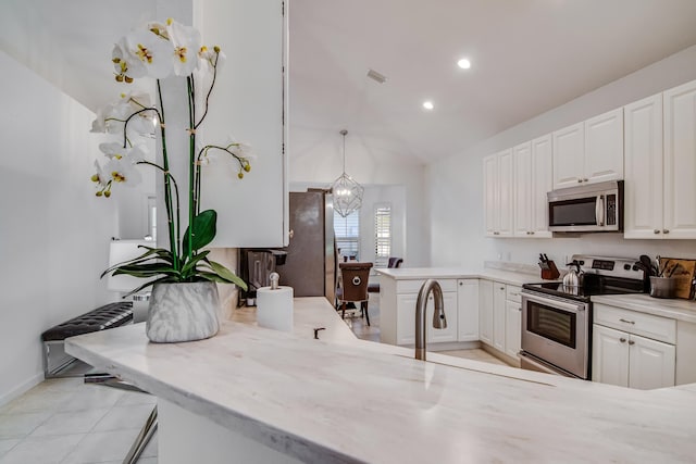 kitchen with white cabinetry, decorative light fixtures, stainless steel appliances, and a notable chandelier