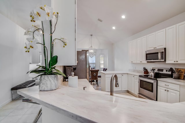 2156 Wightman Dr, Wellington, FL 33414 - kitchen featuring a peninsula, appliances with stainless steel finishes, white cabinetry, and lofted ceiling