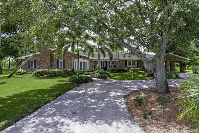 ranch-style house featuring a front yard and a carport