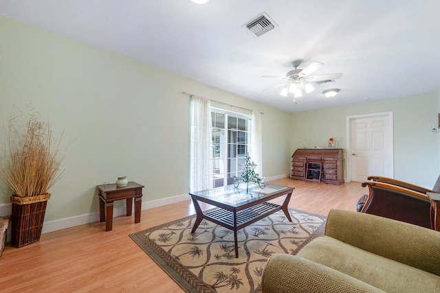 living room with light hardwood / wood-style flooring and ceiling fan