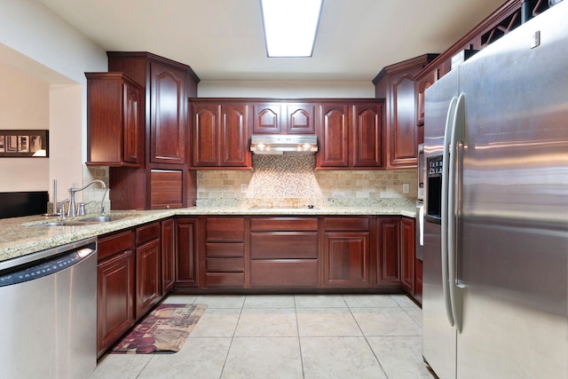 kitchen featuring light stone countertops, light tile patterned floors, stainless steel appliances, and sink