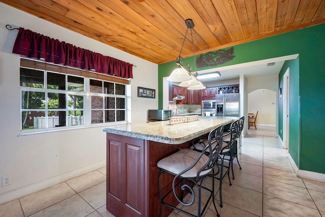 kitchen with kitchen peninsula, light stone countertops, stainless steel appliances, wooden ceiling, and hanging light fixtures