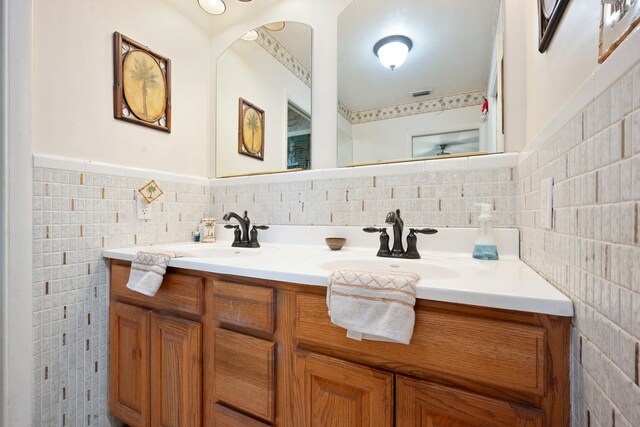 bathroom with vanity and tile walls