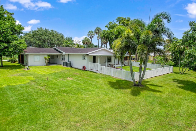 rear view of house with a lawn and central AC