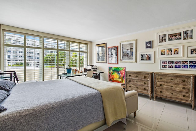 tiled bedroom with ornamental molding and access to exterior