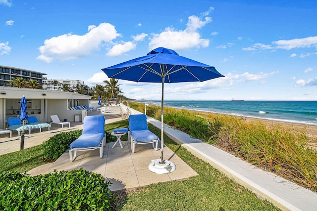 view of patio / terrace with a water view and a view of the beach