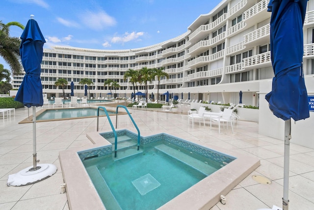 view of pool featuring a community hot tub and a patio