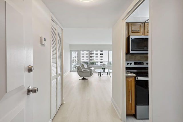 corridor with light hardwood / wood-style floors