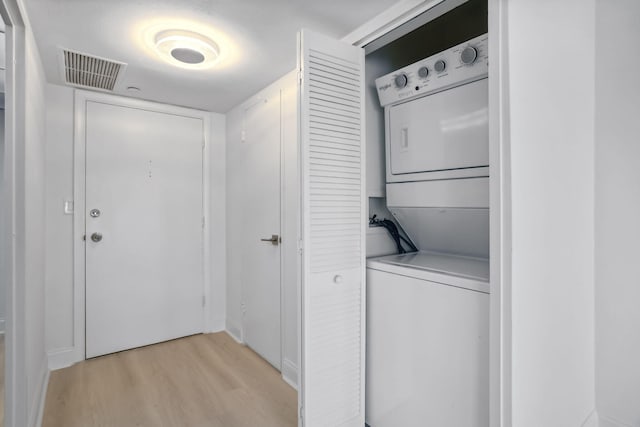 washroom with washer hookup, stacked washer and dryer, and light hardwood / wood-style floors