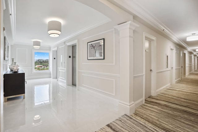 hall with decorative columns, ornamental molding, light tile flooring, and elevator