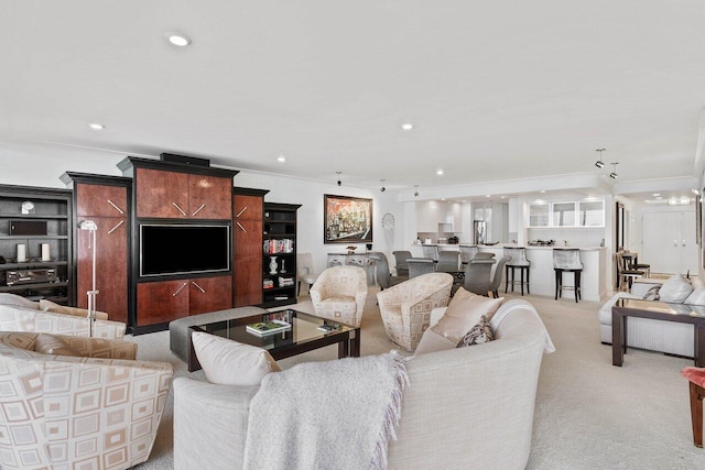 living room with an inviting chandelier, ornamental molding, and light colored carpet