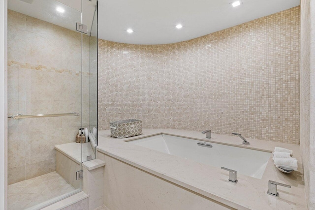 bathroom with a tile shower and tile walls