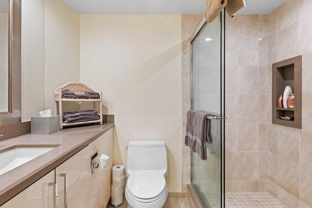 bathroom featuring oversized vanity, toilet, a shower with door, and tile flooring