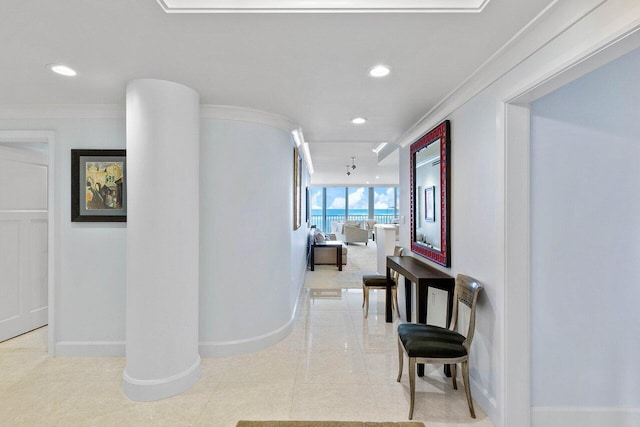 corridor with ornamental molding and light tile floors