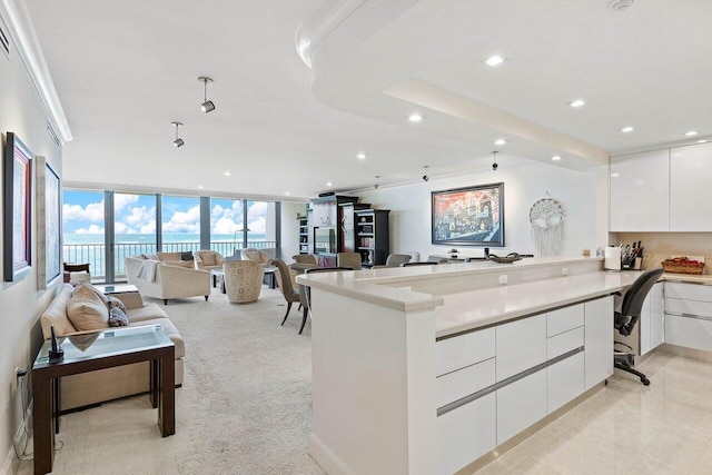 kitchen with floor to ceiling windows, a breakfast bar area, white cabinets, and light tile floors