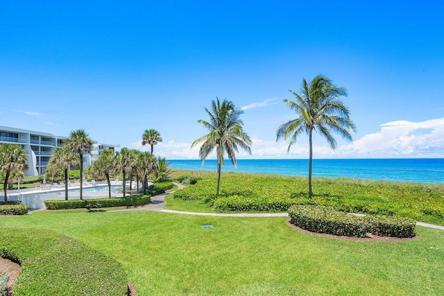 view of home's community with a water view and a lawn