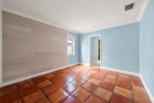 tiled empty room featuring crown molding and wood walls