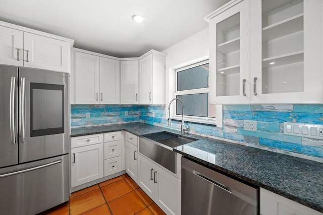 kitchen featuring tasteful backsplash, white cabinetry, appliances with stainless steel finishes, and sink