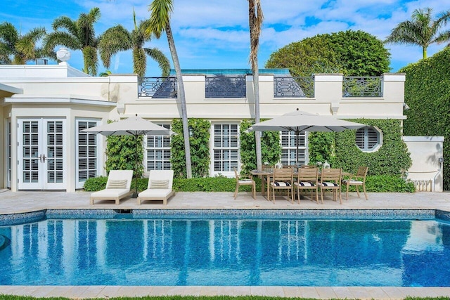 view of pool featuring a patio area and french doors