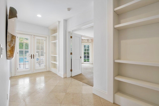 carpeted foyer featuring french doors and a healthy amount of sunlight