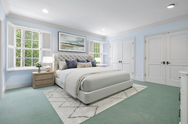 bedroom with light colored carpet, two closets, and crown molding