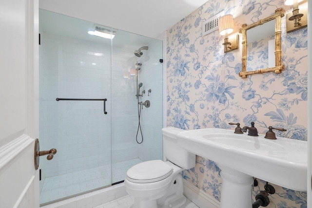 bathroom with a shower with door, toilet, and tile flooring