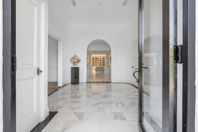 hall with ornamental molding and tile flooring