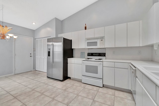 kitchen with white cabinets, light tile floors, a chandelier, and white appliances