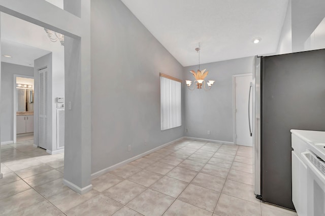 tiled spare room featuring a notable chandelier and vaulted ceiling