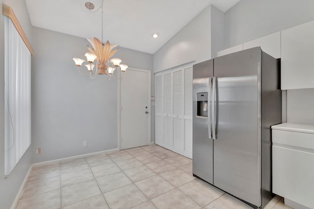 kitchen with a chandelier, light tile floors, white cabinetry, and stainless steel refrigerator with ice dispenser