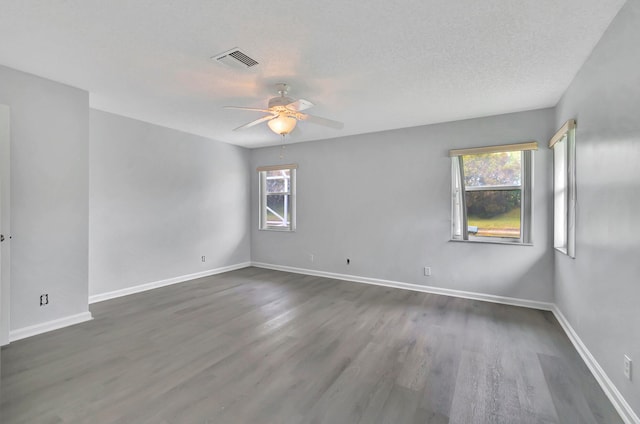 unfurnished room with ceiling fan, a textured ceiling, and dark hardwood / wood-style flooring