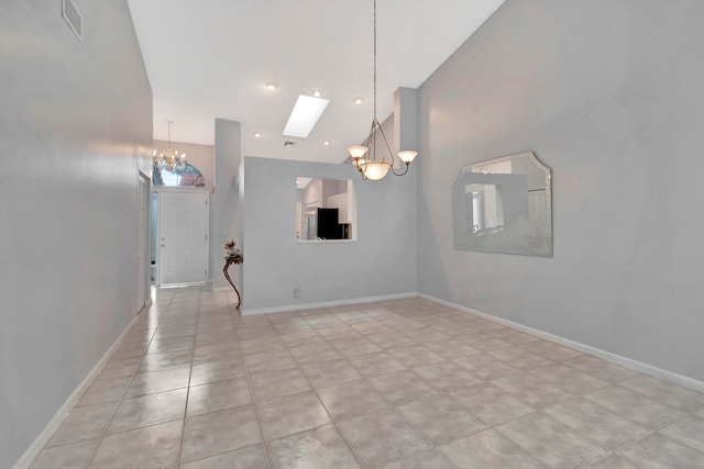 tiled spare room with a notable chandelier and a skylight