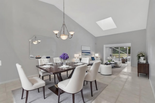 dining space with a chandelier, a skylight, light tile floors, and high vaulted ceiling