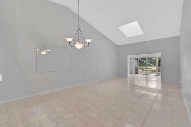 spare room with a notable chandelier, a skylight, high vaulted ceiling, and light tile flooring