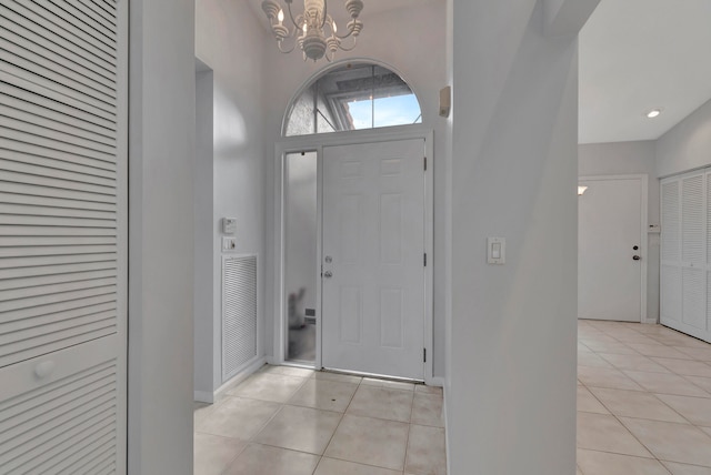 tiled entryway featuring an inviting chandelier