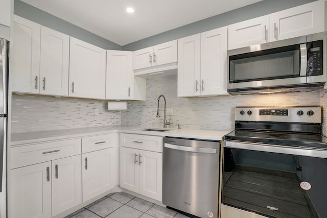 kitchen with appliances with stainless steel finishes, white cabinets, and tasteful backsplash